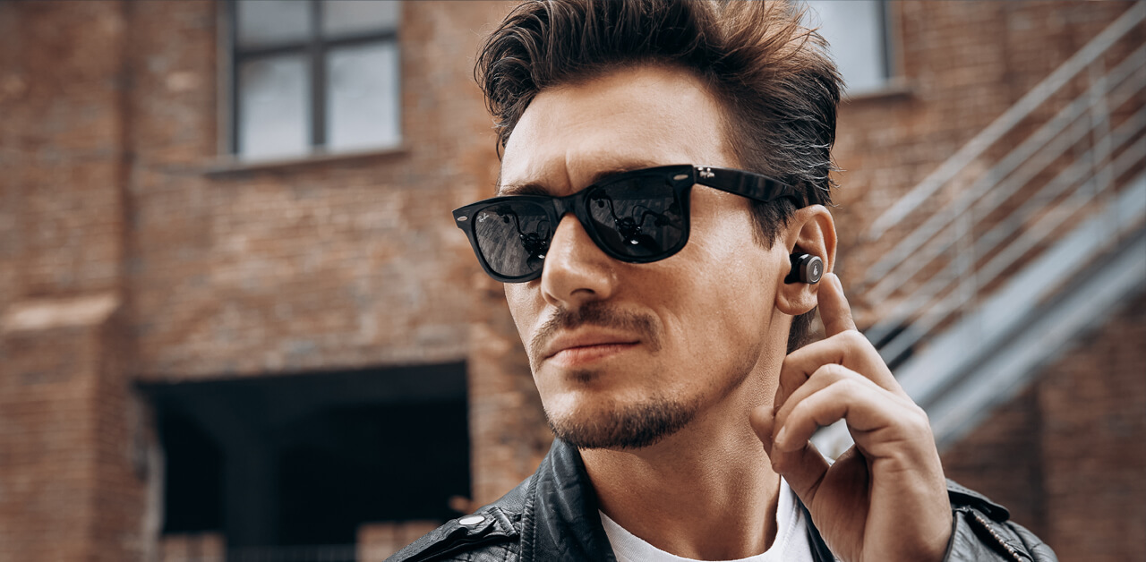 A man in sunglasses, wearing headphones